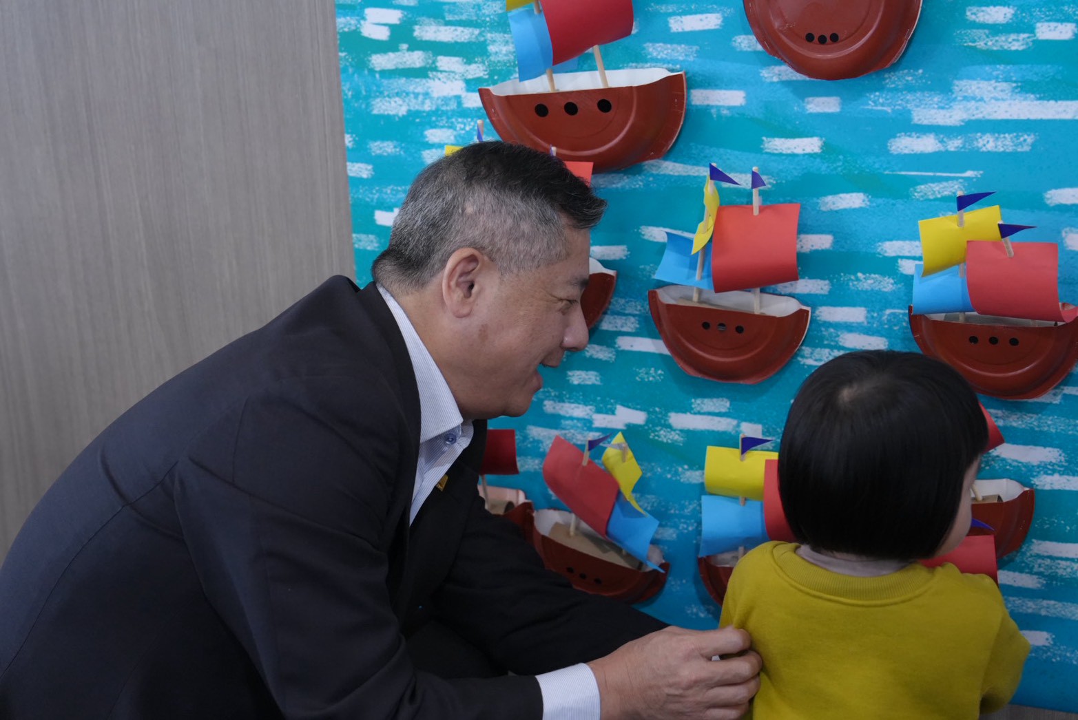 6.王錦榮總經理攜手小朋友張貼傳承小帆船，場面溫馨，傳遞城市記憶與港口文化。